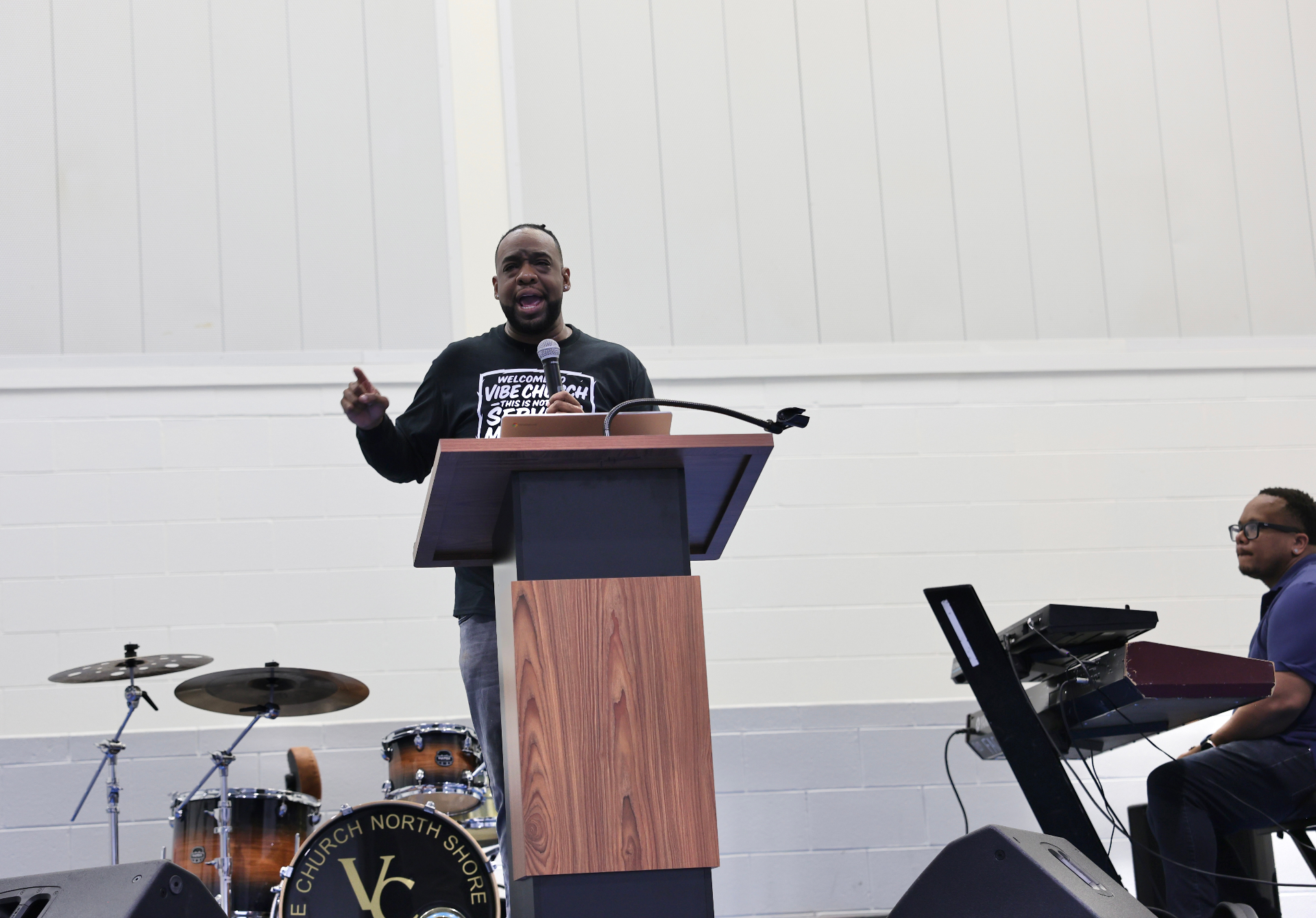 Pastor Henderson preaching in a Vibe Church t-shirt