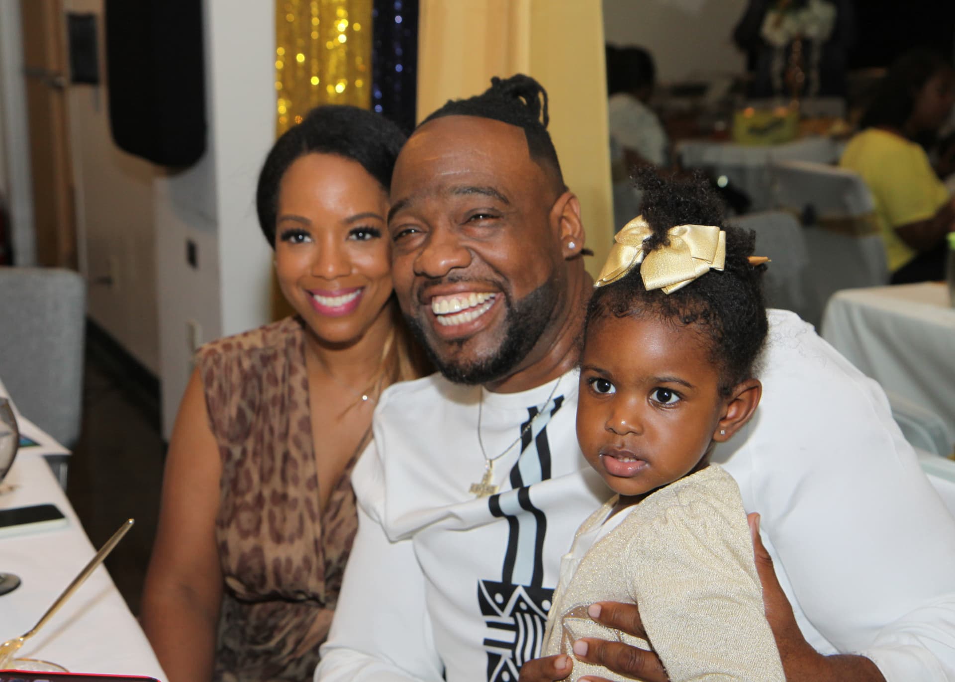 Pastor Lo smiling with his wife and daughter at the celebration