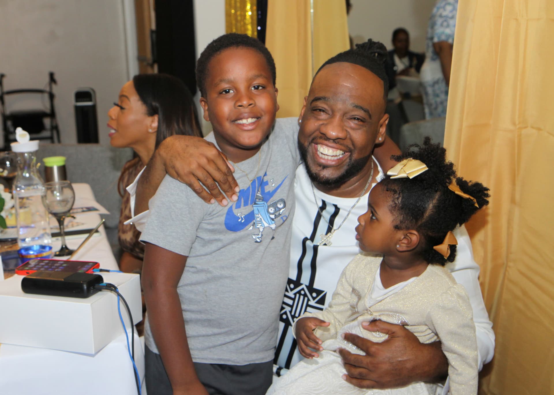 Pastor Lo hugging two of the children at the celebration