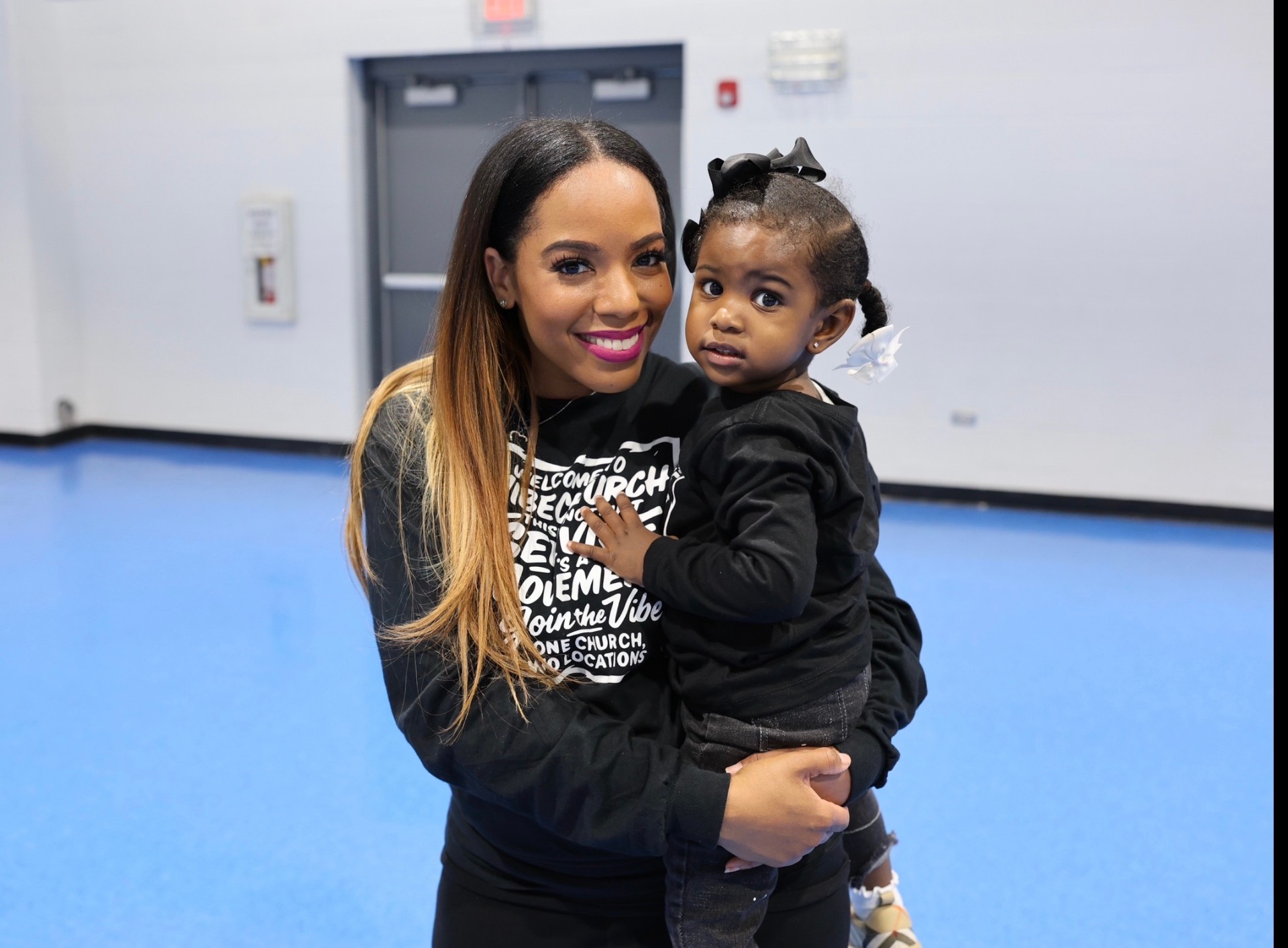 Lady Tamika smiling while holding Lael