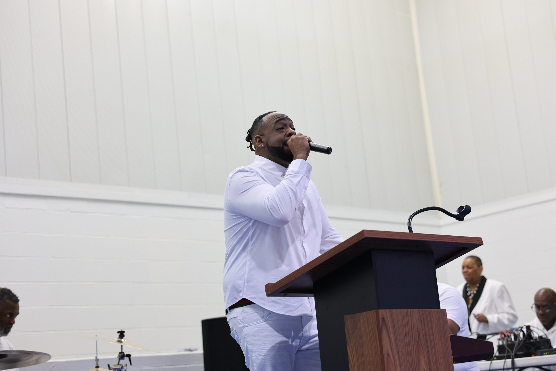 Pastor Henderson singing into the microphone on Pentecost Sunday