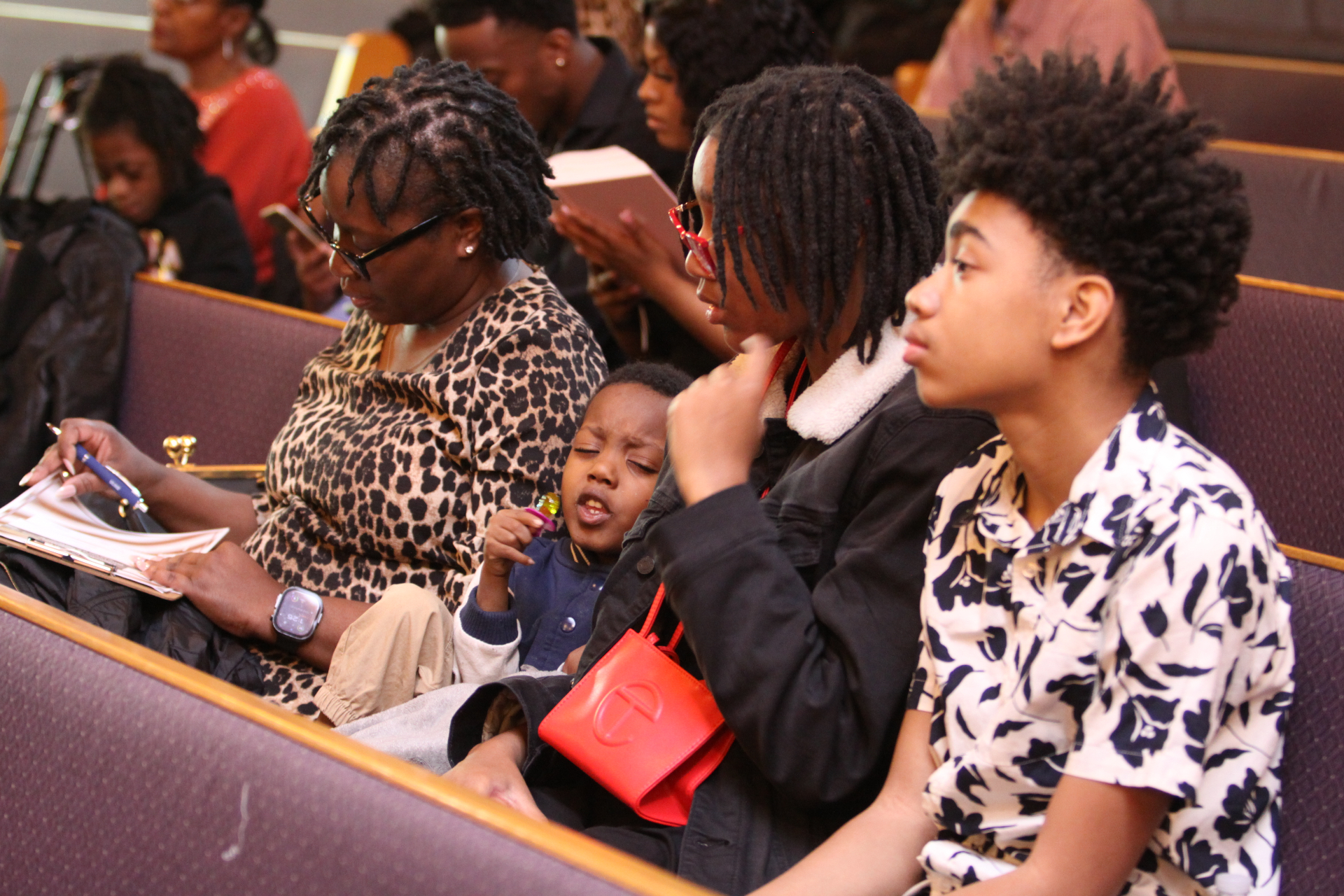 Family seated together in church during the baptism service
