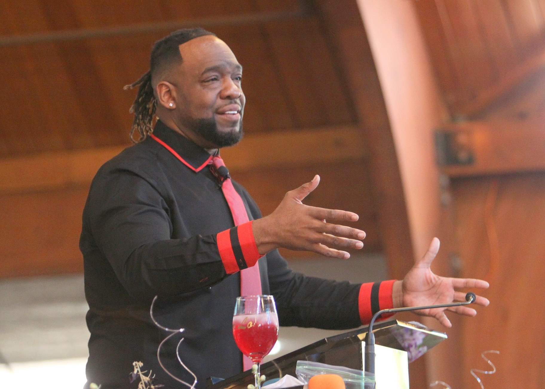Pastor Henderson preaching with open hands at the pulpit