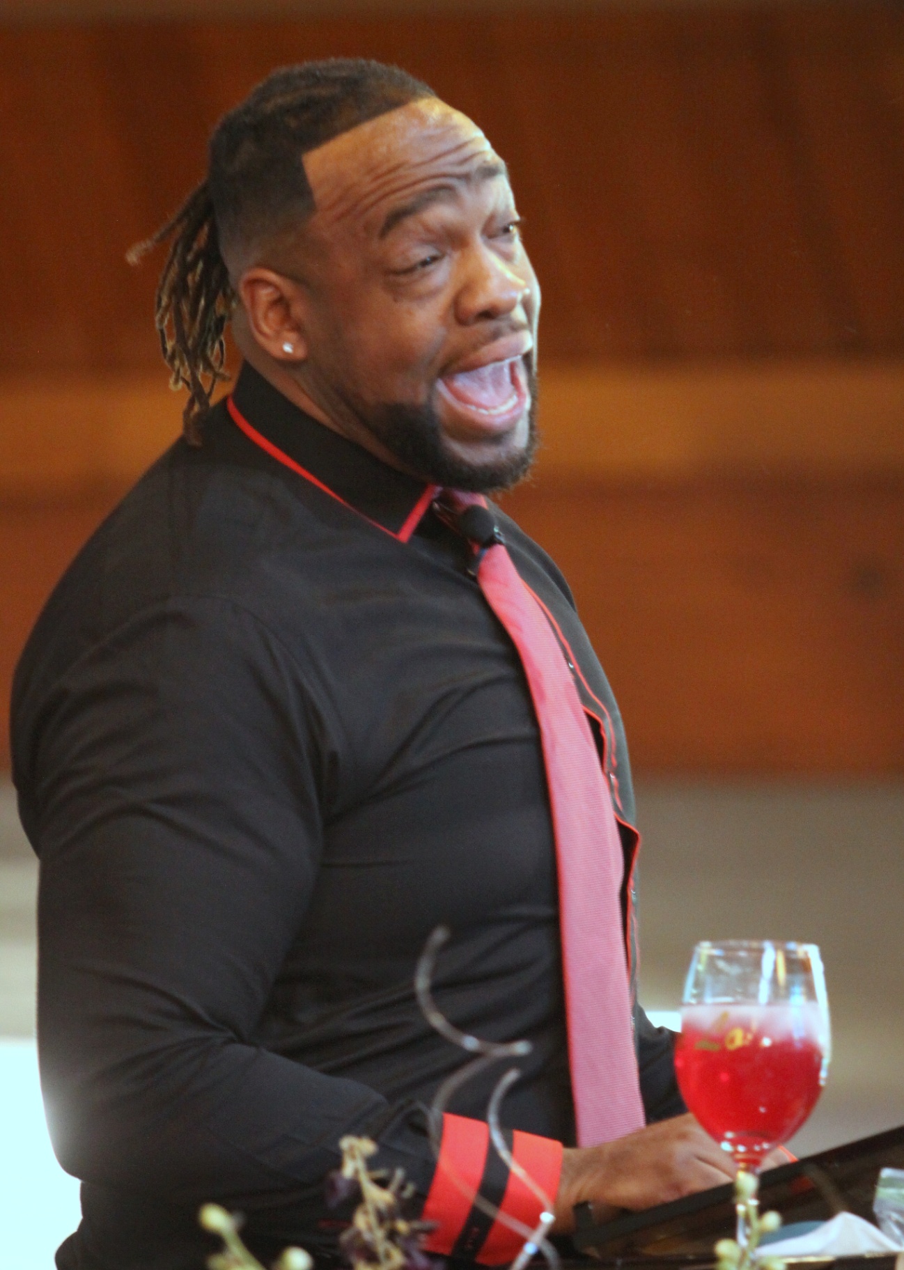 Pastor Henderson preaching with joyful expression during service