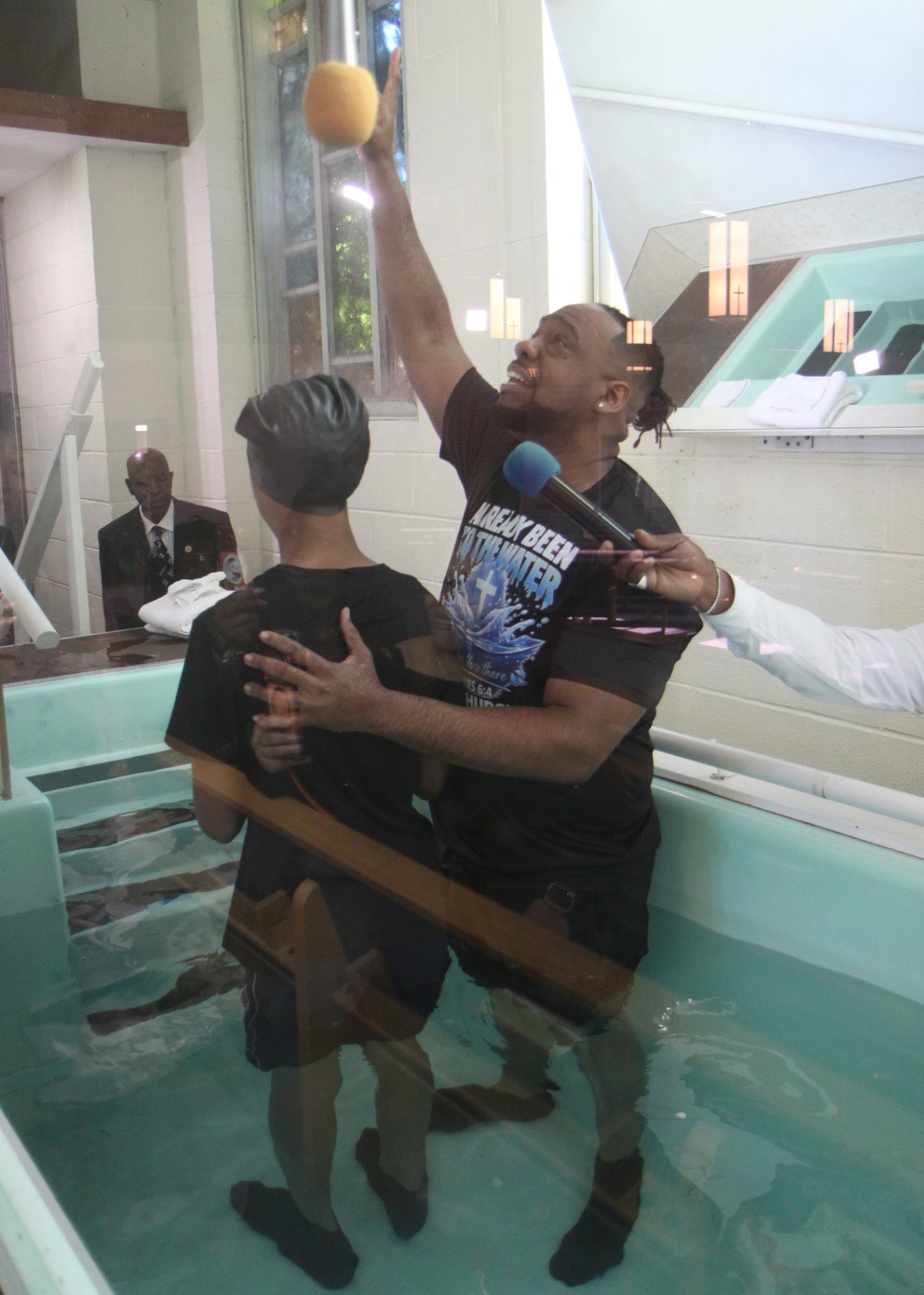 Pastor Henderson lifting hands in praise during baptism