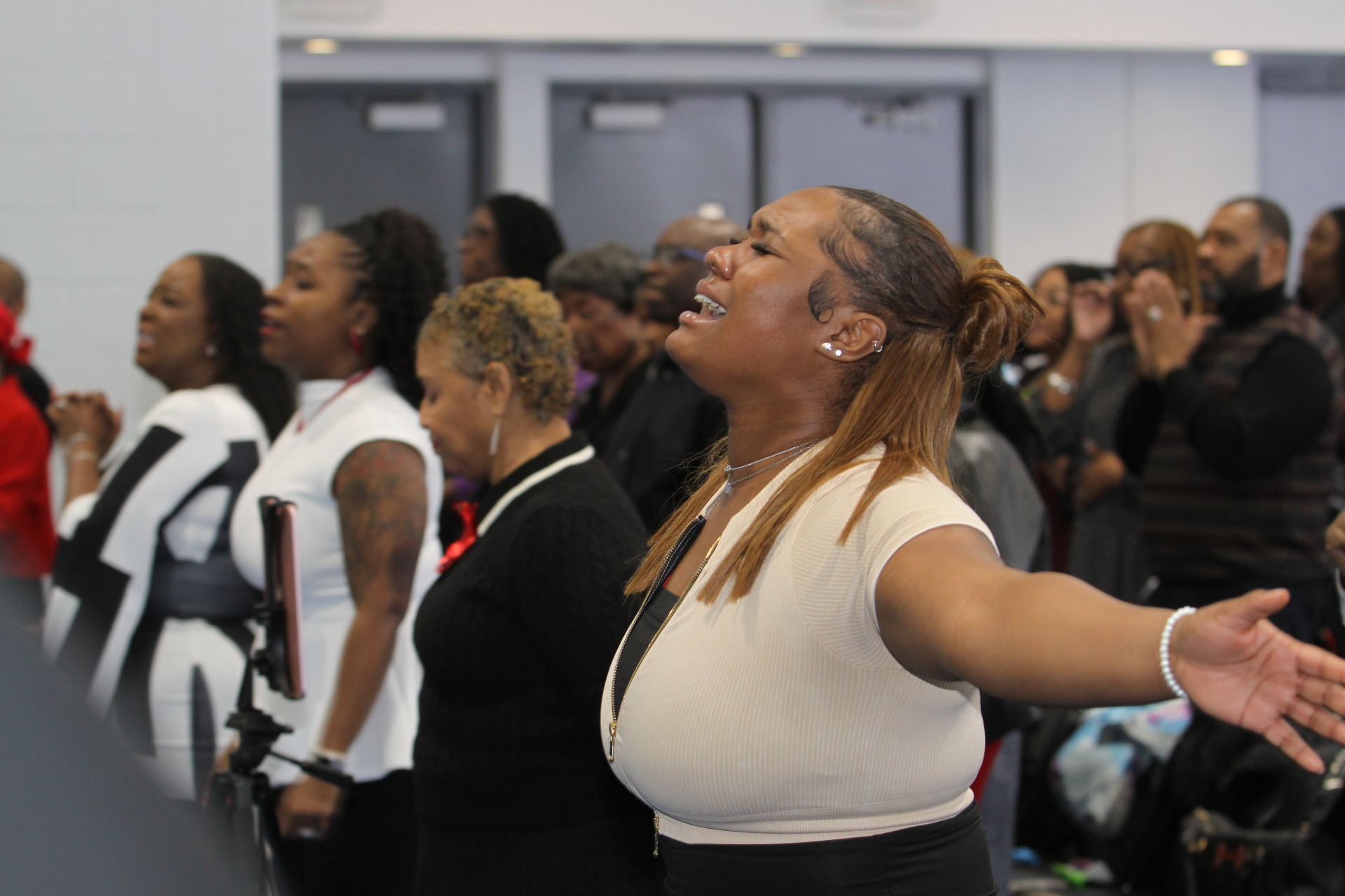 Worshippers with arms outstretched lifting praise