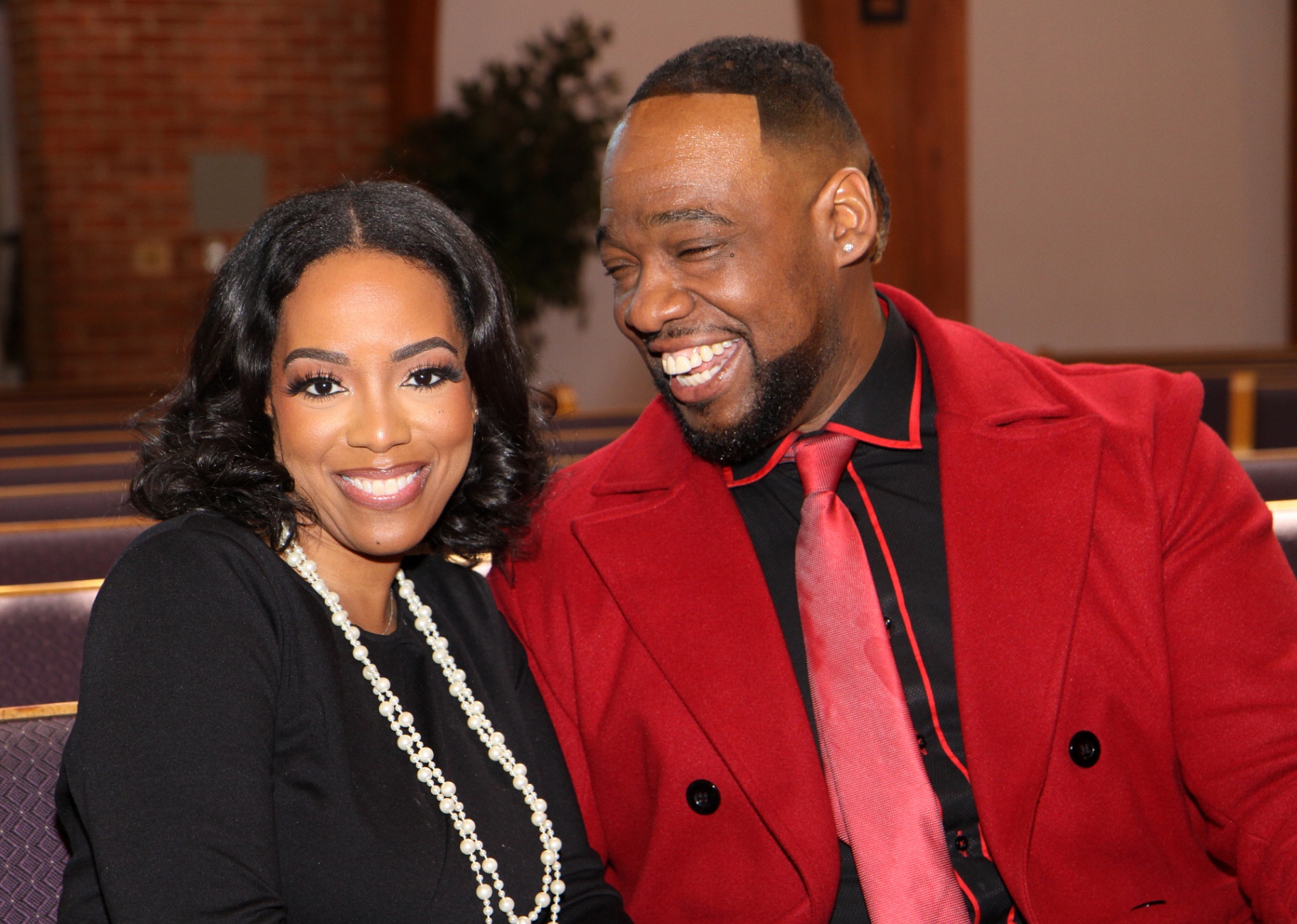 Pastor Henderson and First Lady Tamika smiling together in the sanctuary