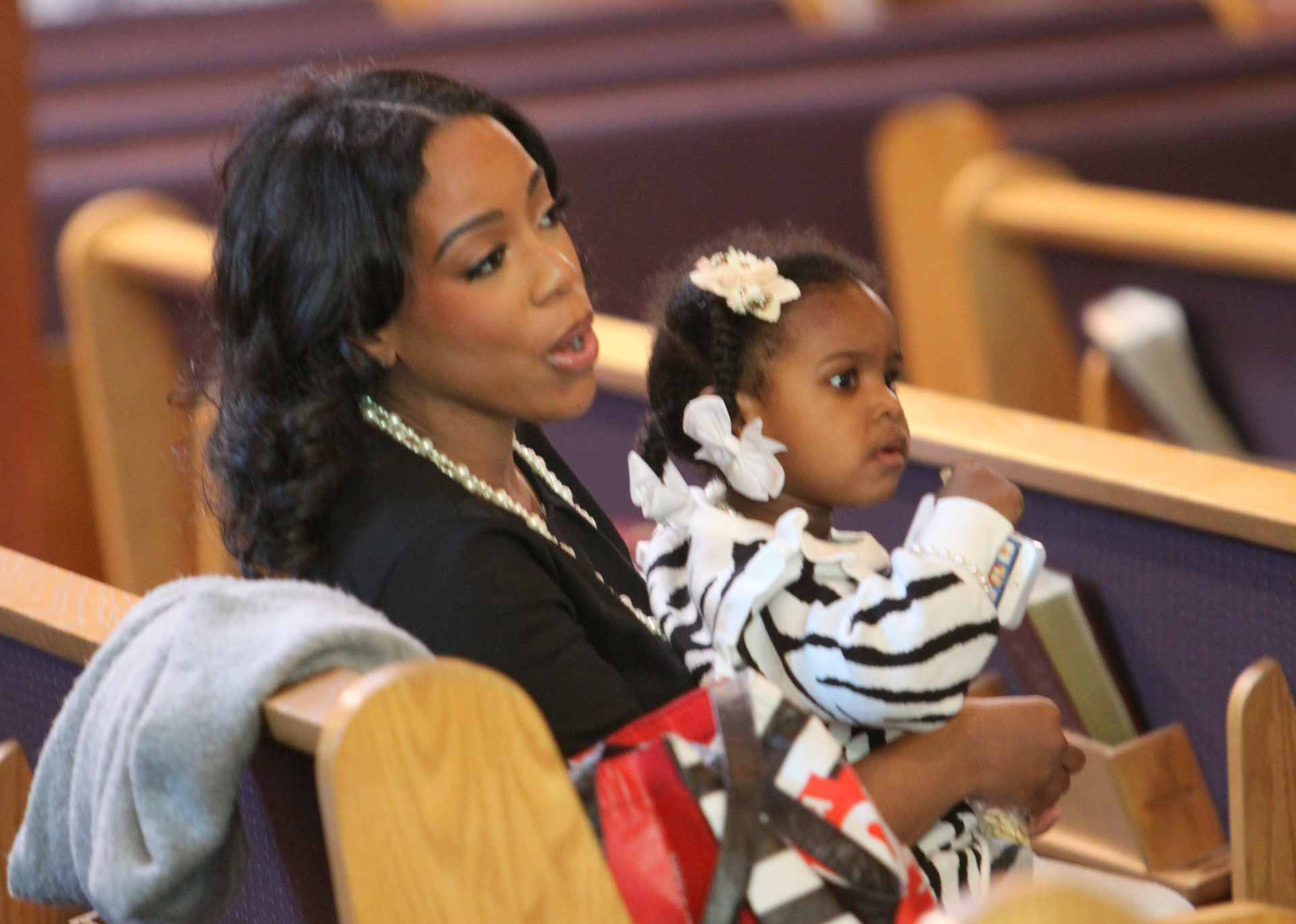 Mother and young daughter seated together in the sanctuary